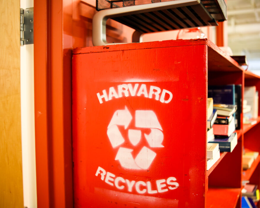"Harvard Recycles" sign on a red bookshelf.