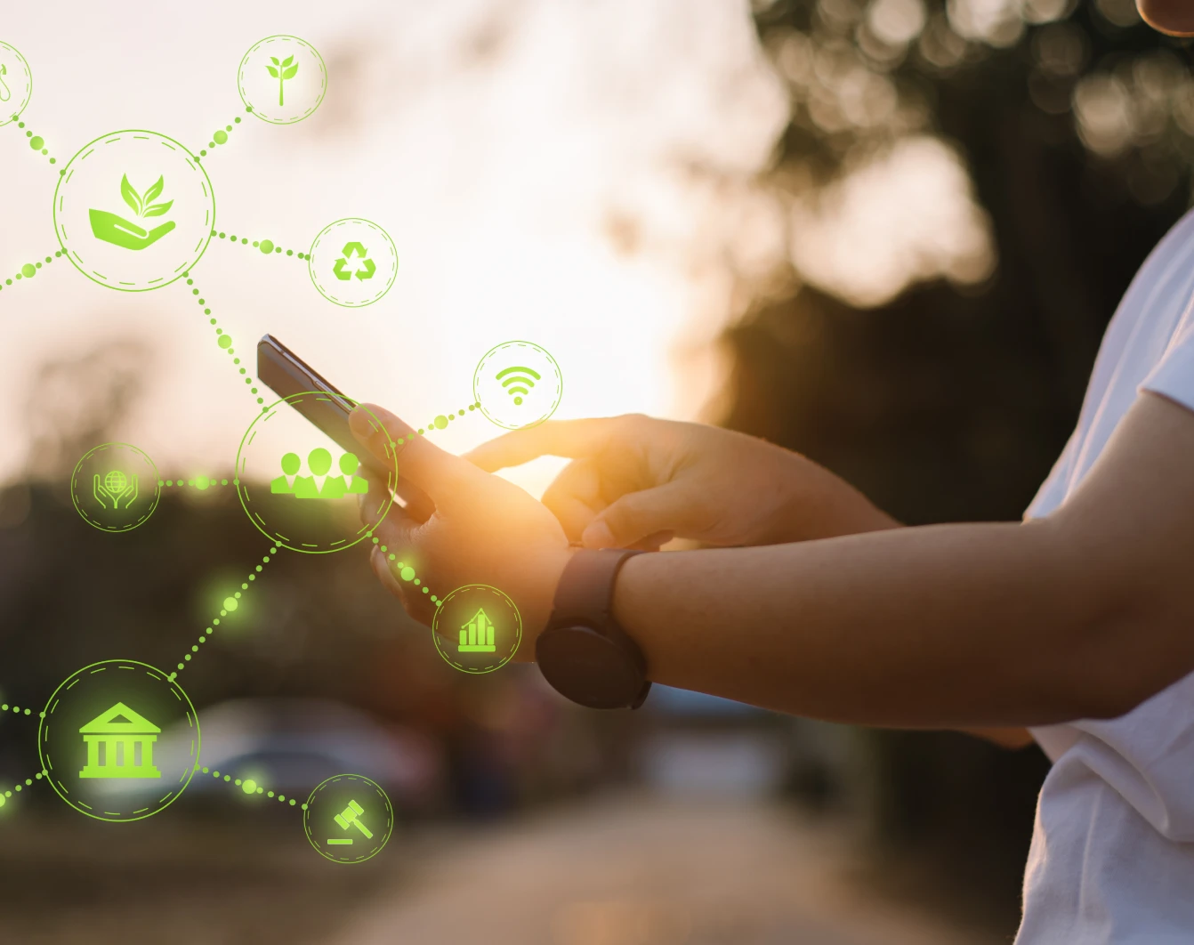 Photo of a person holding a phone with green graphic icons around it that reprsent climate, like a building, plants, etc.