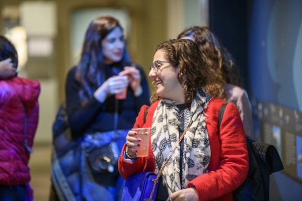 A person has a drink at an Arts Thursday event.