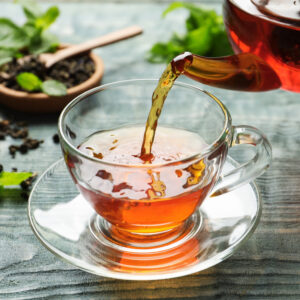 Tea. being poured into a glass mug