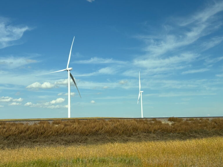 Wind turbines against a blue sky.