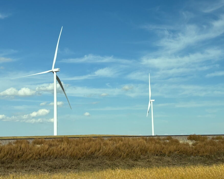 Wind turbines against a blue sky.